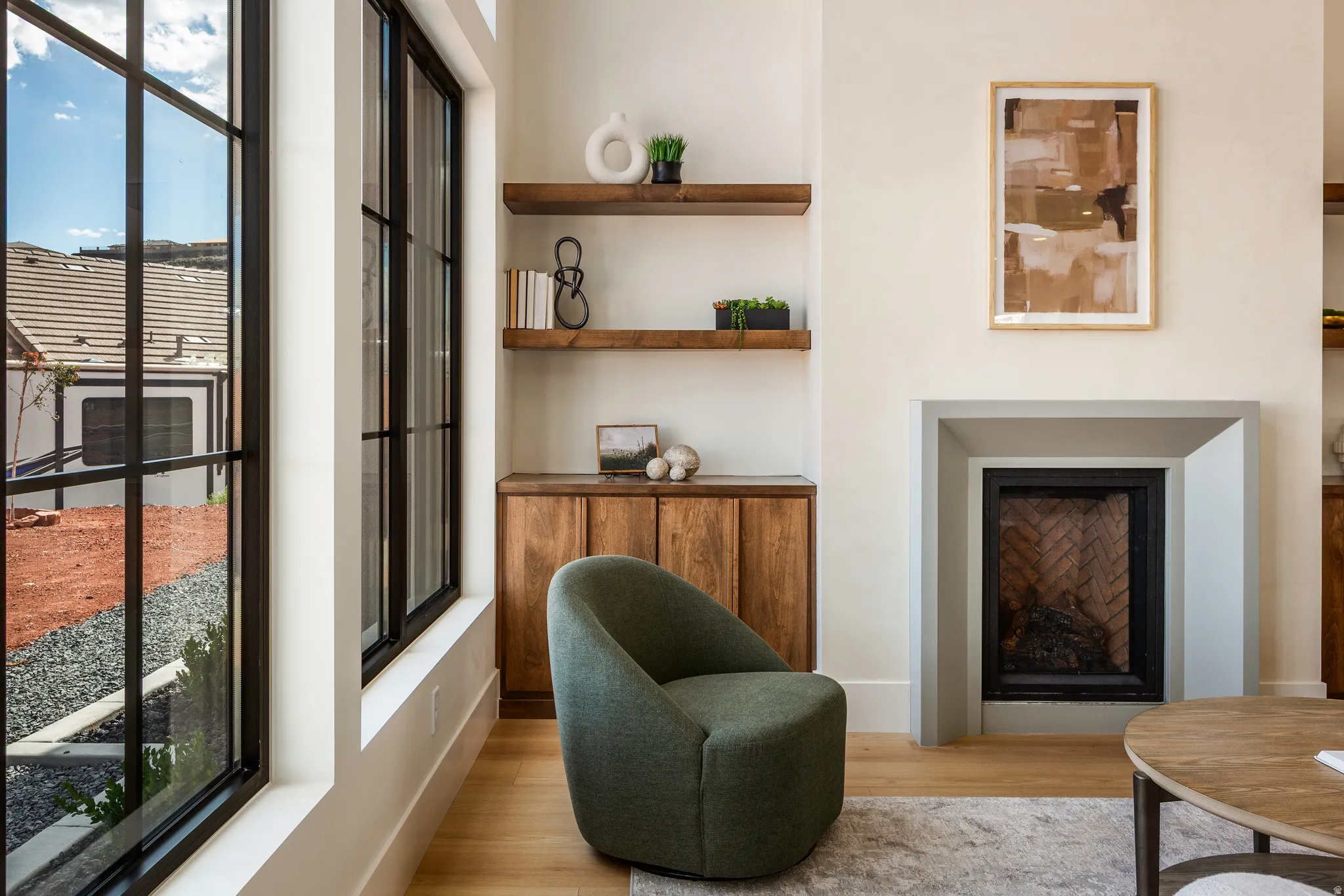 Expansive black-framed windows complement light wood-finish flooring