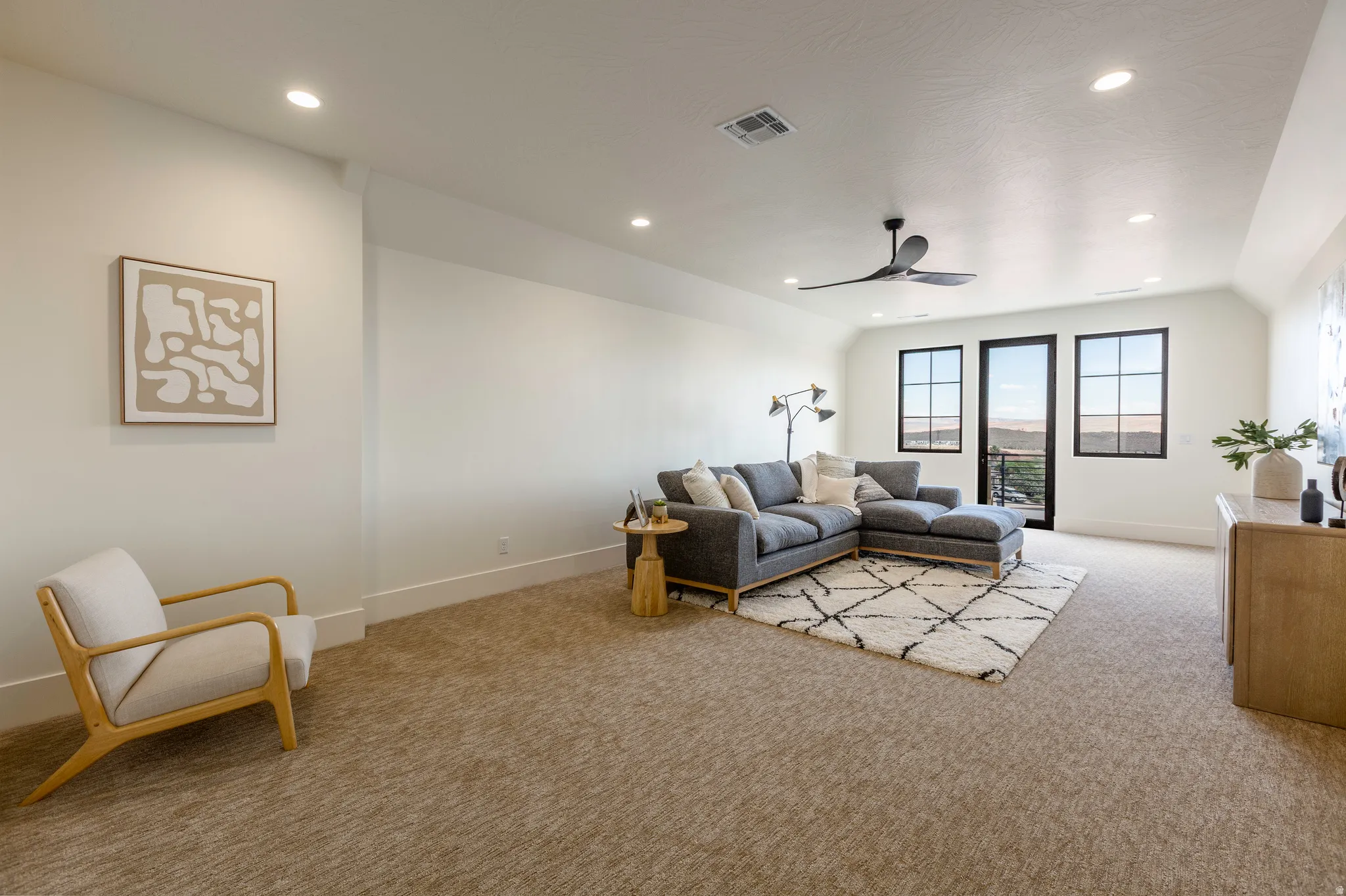 Spacious room featuring carpeted flooring, recessed lighting, and a dark-toned ceiling fan