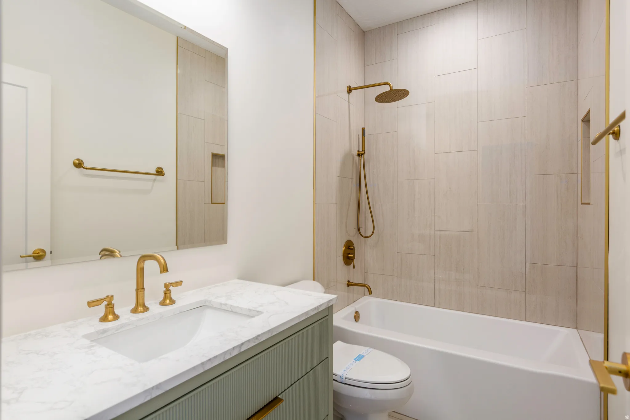 Bathroom featuring a light green vanity with fluted detailing, a white undermount sink, and a white countertop
