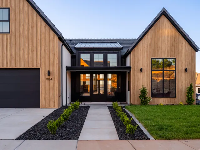 Contemporary facade featuring vertical wood-finish siding, white stucco, and a dark tile roof