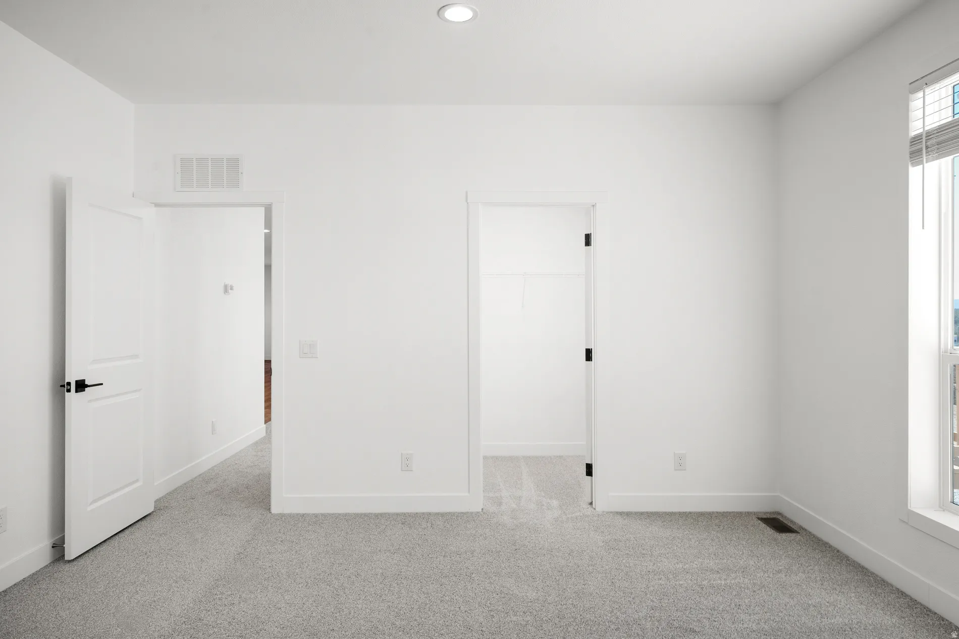 Bright interior space featuring light gray carpet flooring and white walls
