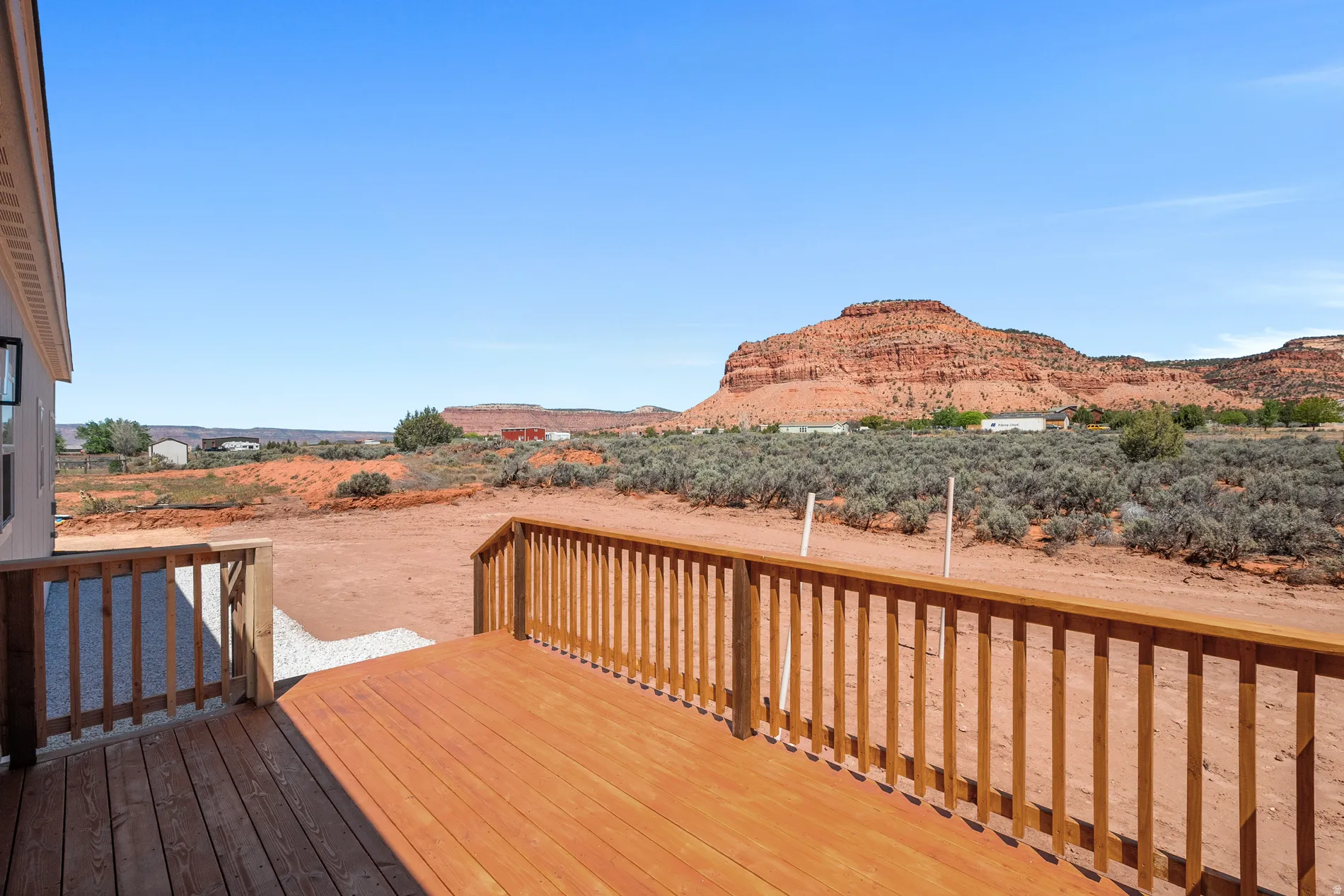Spacious outdoor deck with natural wood railing overlooking a desert landscape