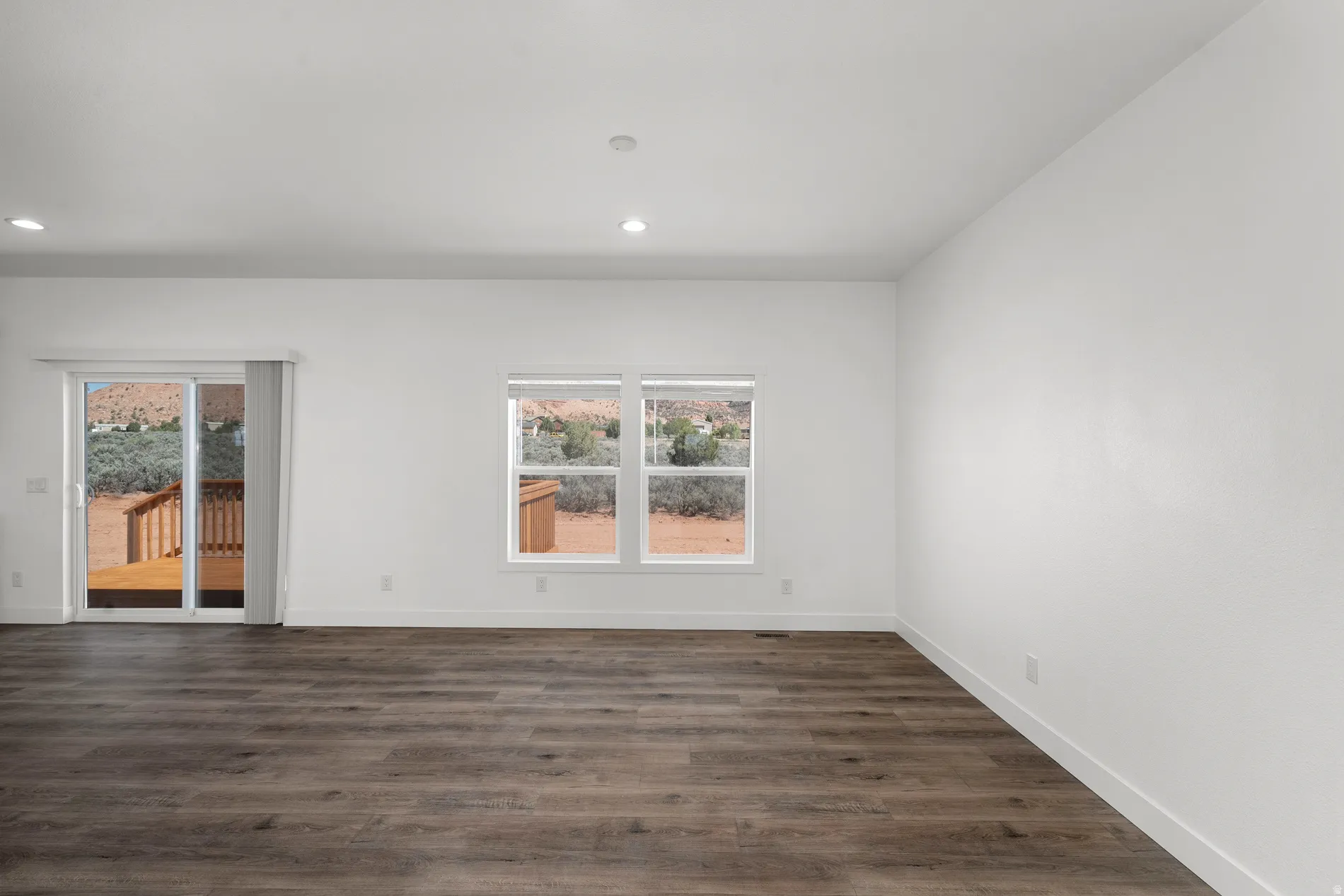 Spacious interior featuring wood-finish flooring, white walls, and recessed lighting