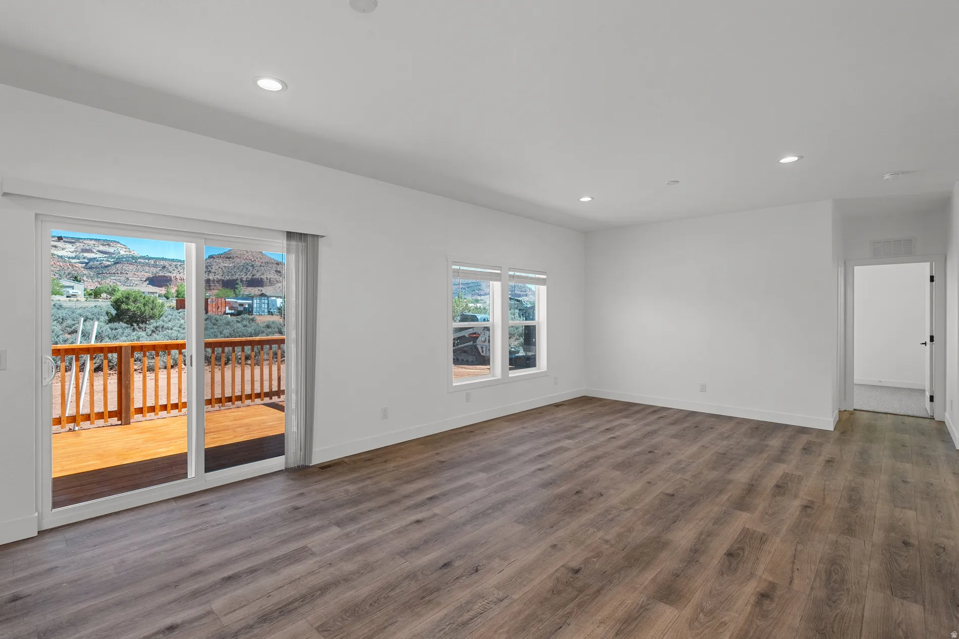 Spacious interior with wood-finish flooring, recessed lighting, and white walls