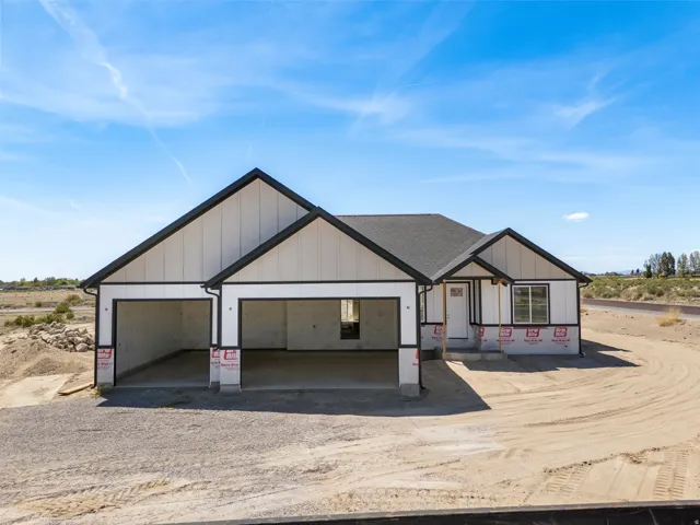 Contemporary single-story residence with a black and white exterior featuring a gabled roofline and a two-car garage