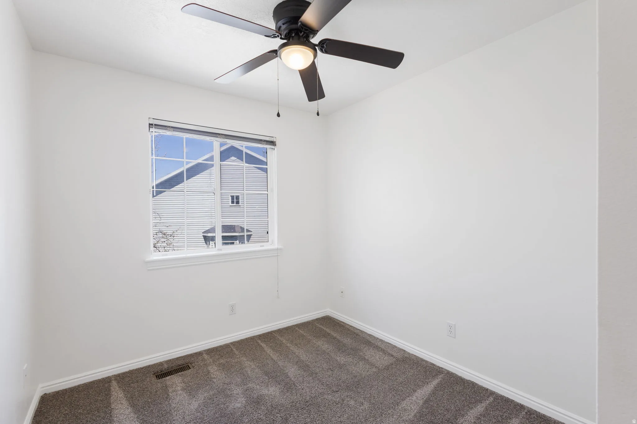 Room with neutral wall color and patterned carpet flooring