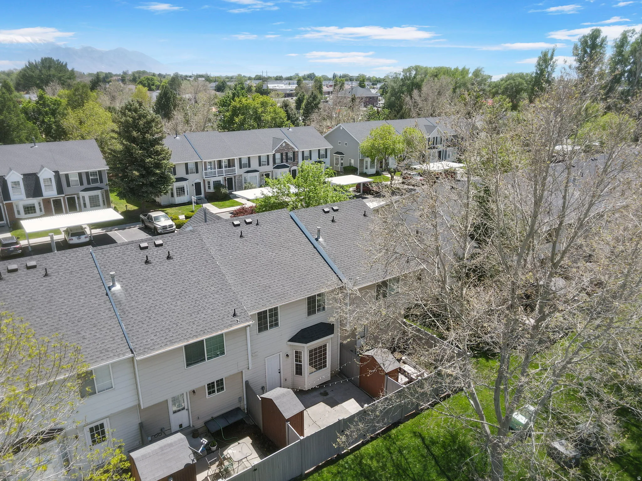 Townhome community with pitched shingle roofs and fenced rear patios