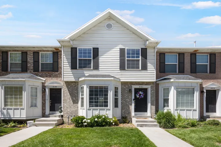 White siding and brick facade with a prominent bay window