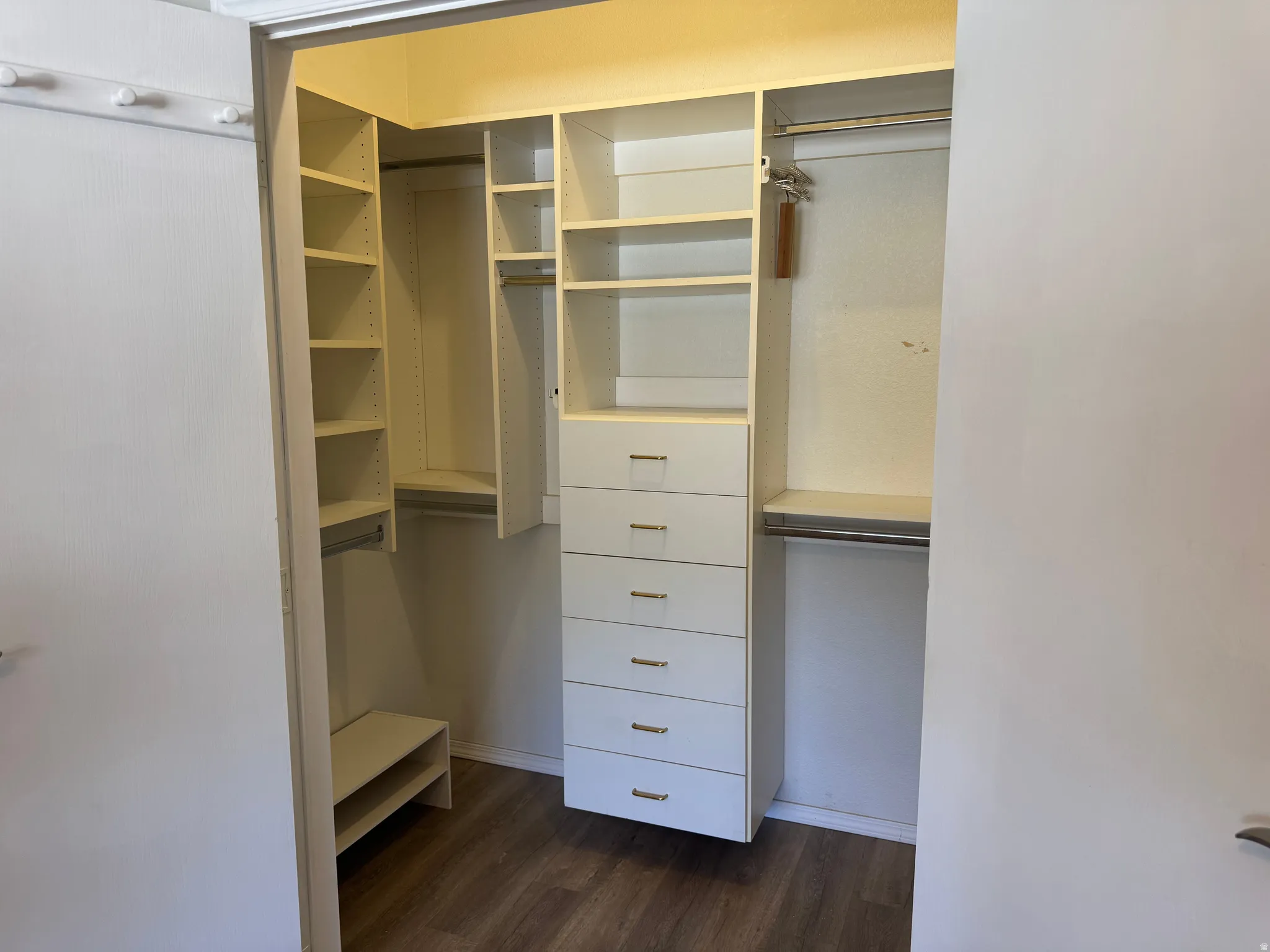 Custom closet system featuring multiple shelves, hanging rods, and built-in drawers