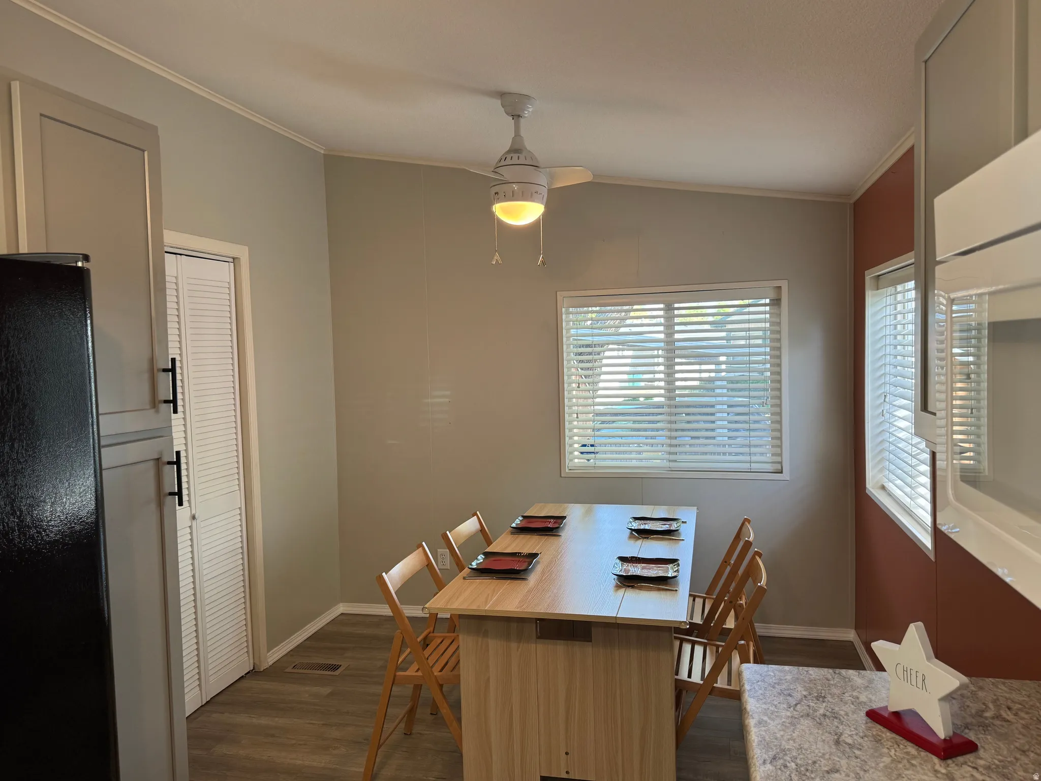 Dining area featuring wood-finish flooring and a ceiling fan with integrated lighting