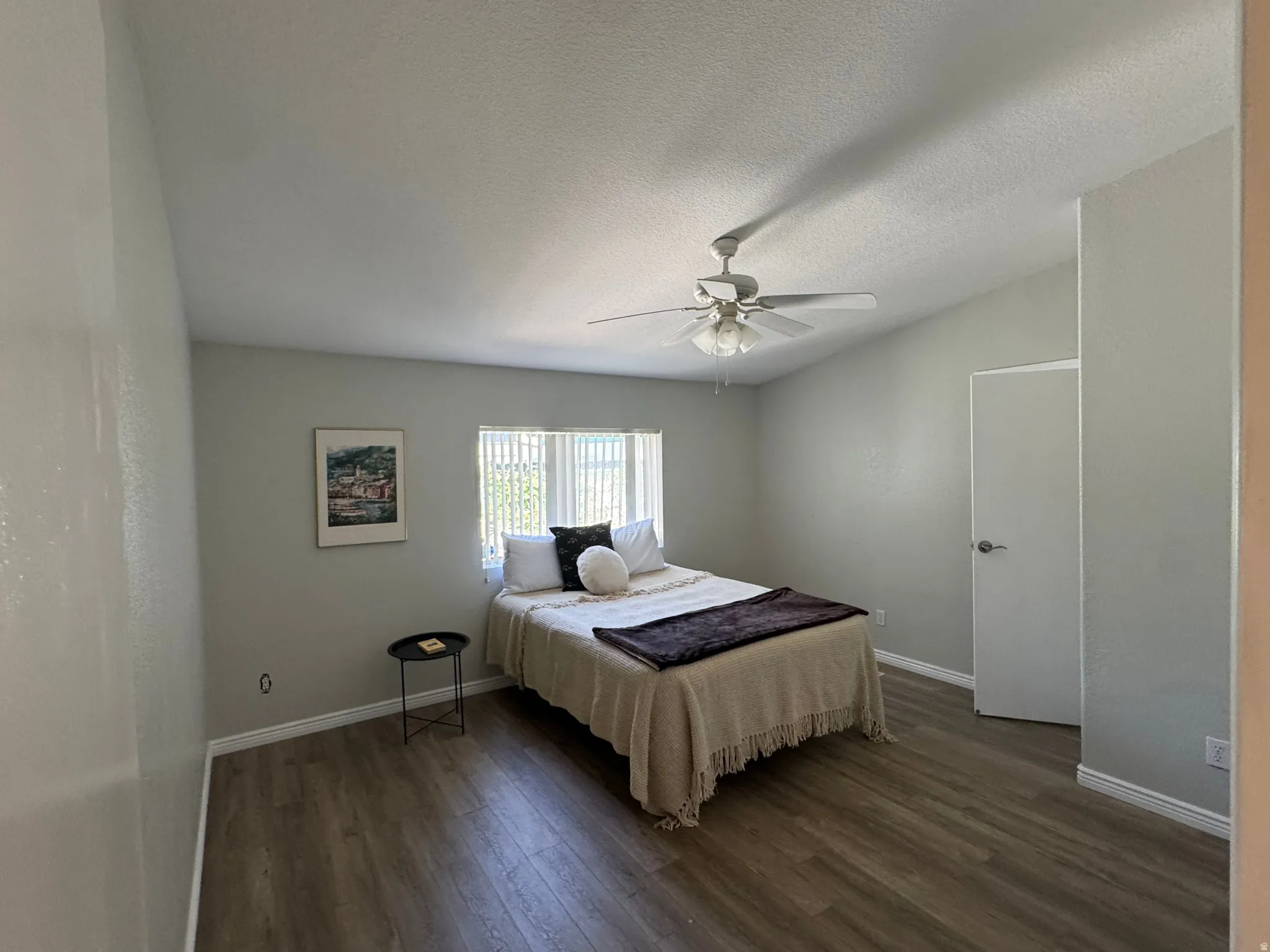 Room featuring vaulted ceilings, wood-finish flooring, and a ceiling fan with integrated lighting