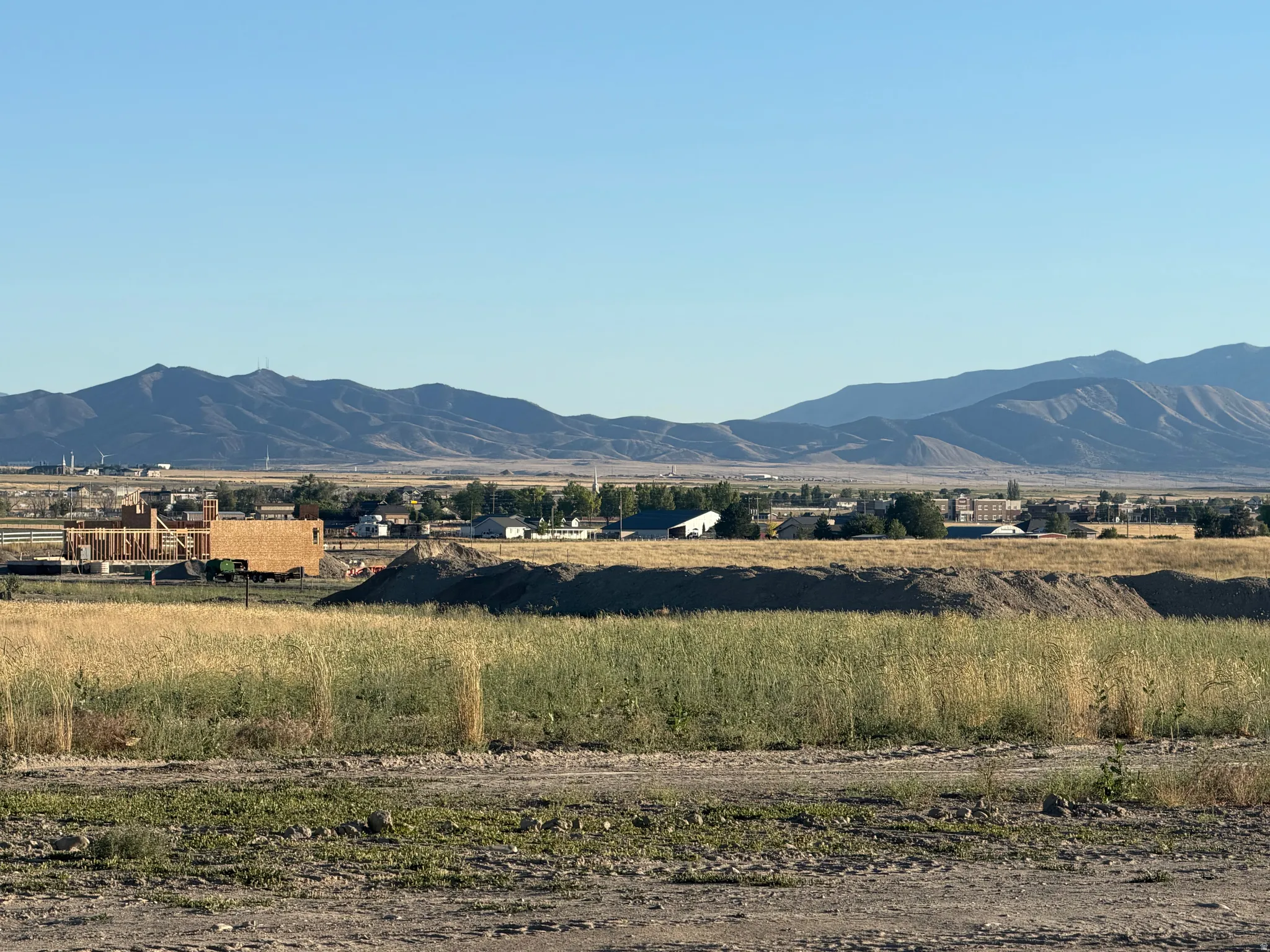 Expansive land parcel featuring natural grasses and distant mountain ranges