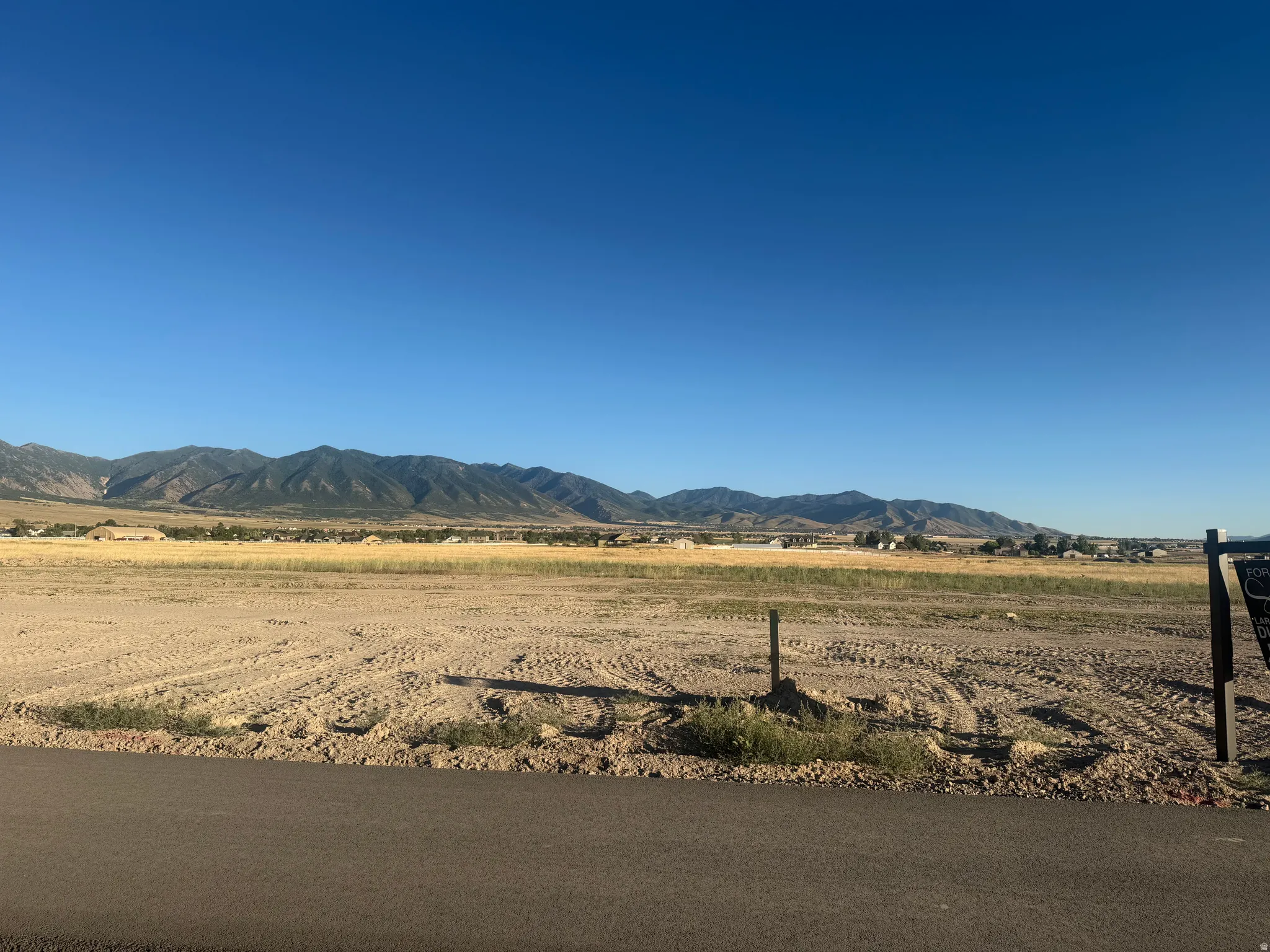 Expansive cleared land parcel with mountain backdrop