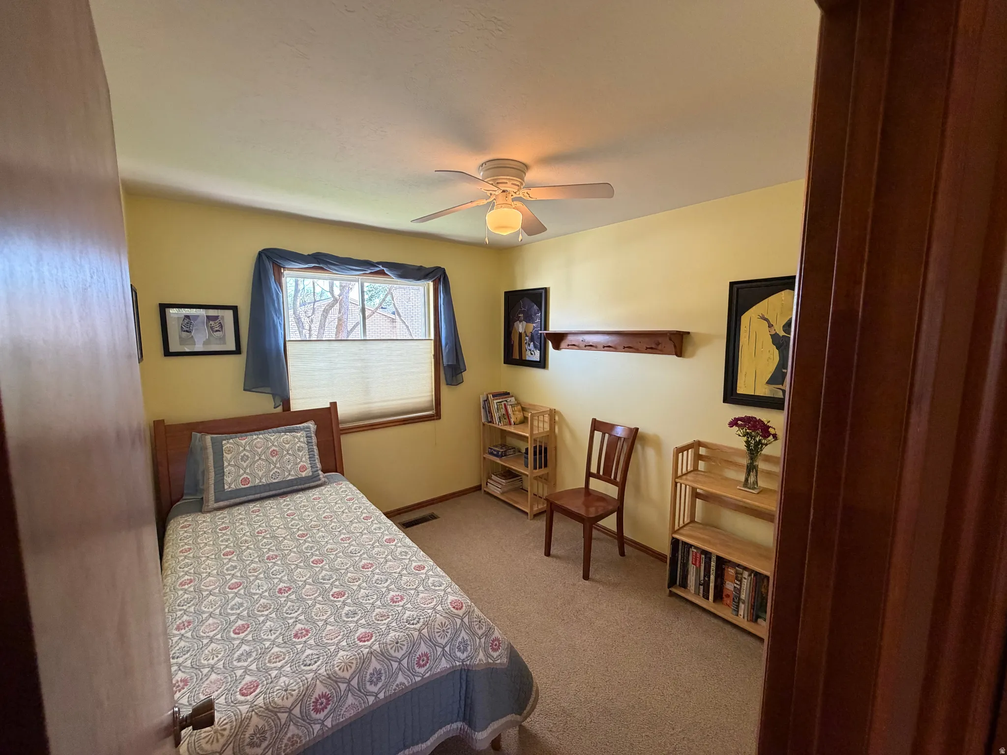 Interior room featuring a ceiling fan with integrated lighting, wood-finish window trim, and wall-to-wall carpeting