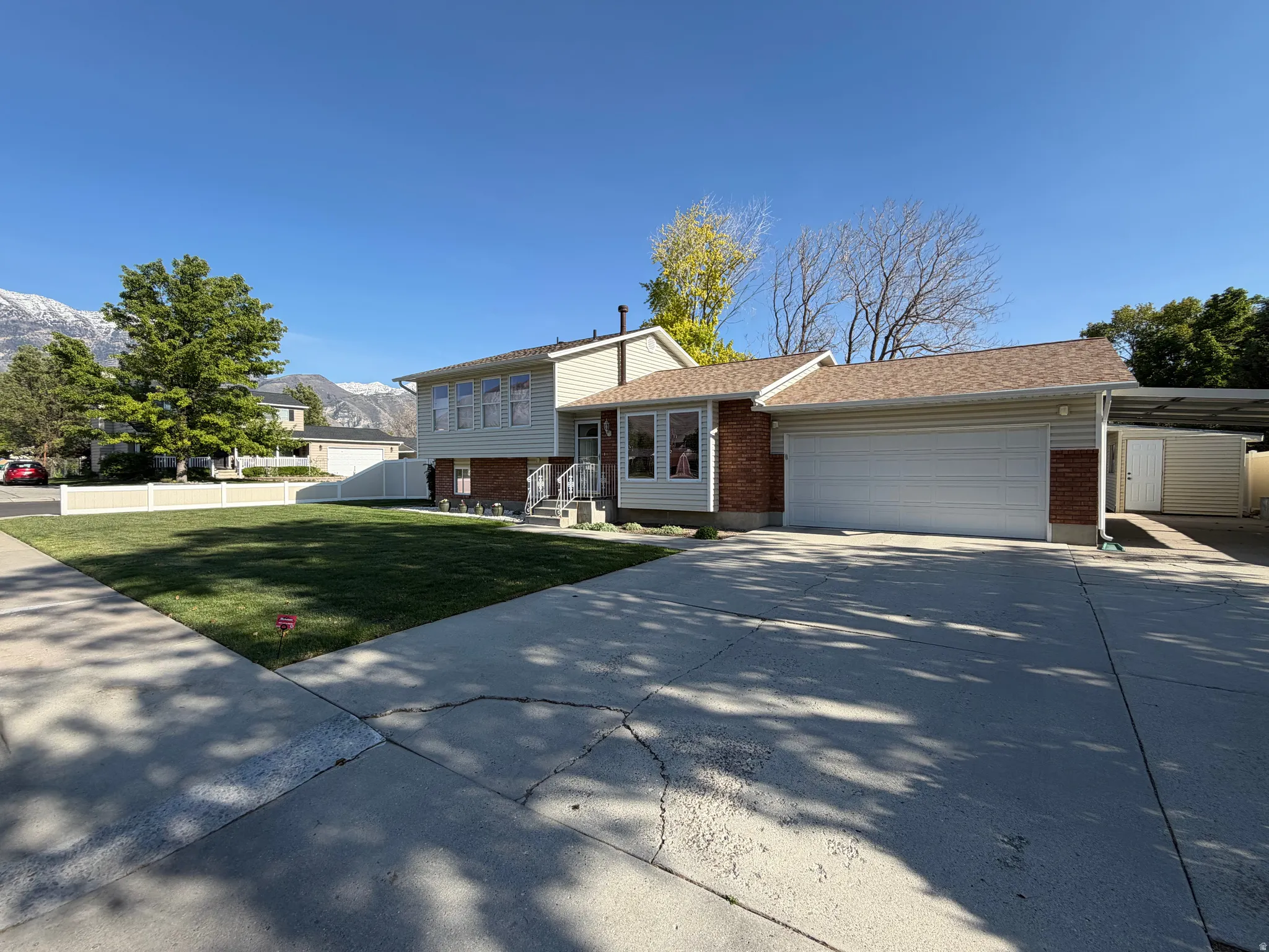 Exterior featuring a two-car garage, brick facade accents, and siding