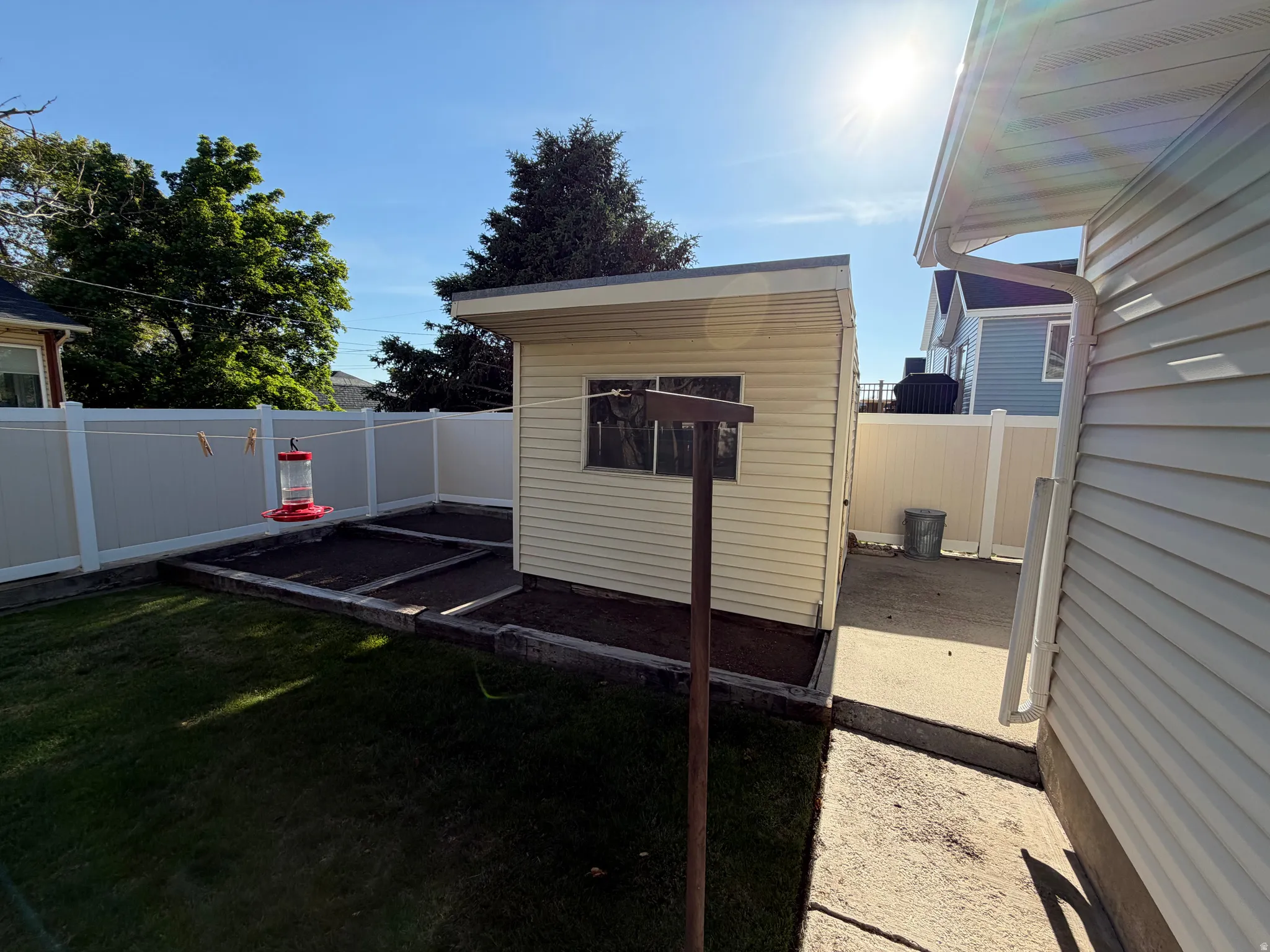 Detached storage shed featuring vinyl siding and a flat roofline