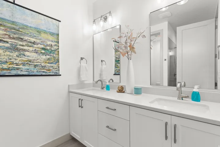 Dual vanity with undermount sinks, stone countertops, and chrome fixtures