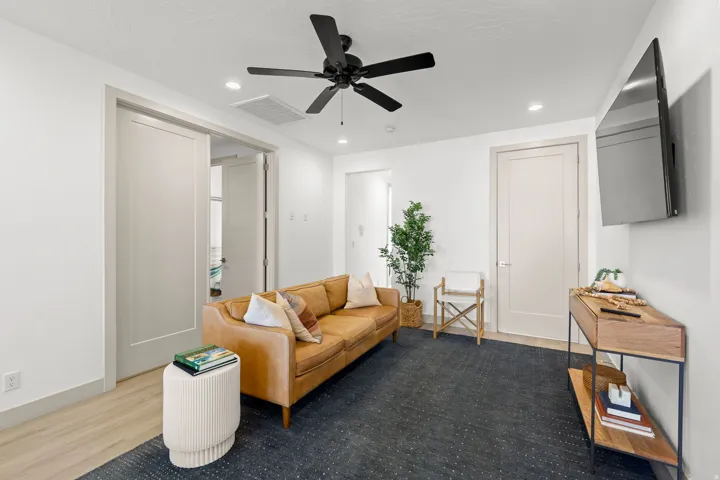 Living area featuring light wood-finish flooring, white walls, and recessed lighting