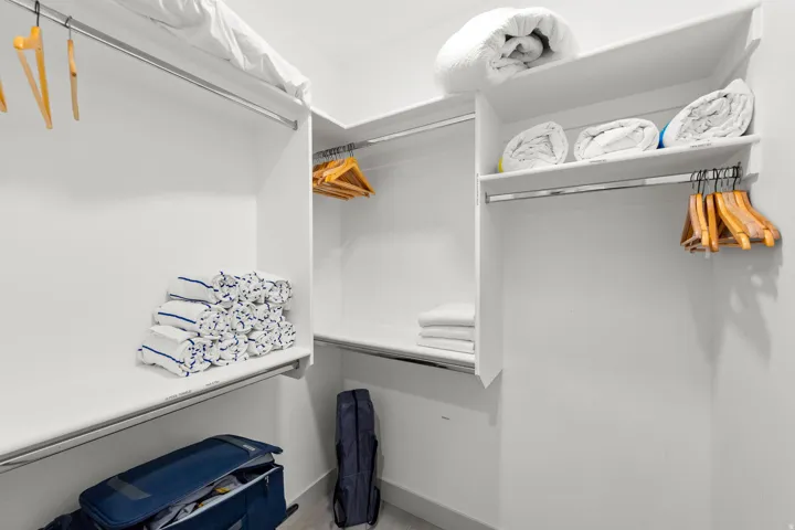 Custom built-in closet system featuring white shelving and chrome hanging rods