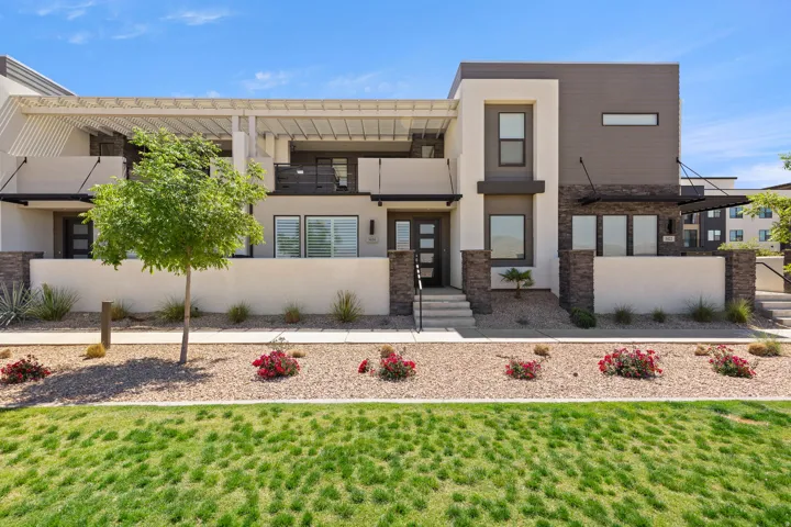 Contemporary multi-story facade featuring varied paneling, stone accents, and a slatted pergola