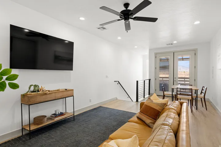 Open-concept living space with light wood-finish flooring, white walls, and recessed lighting