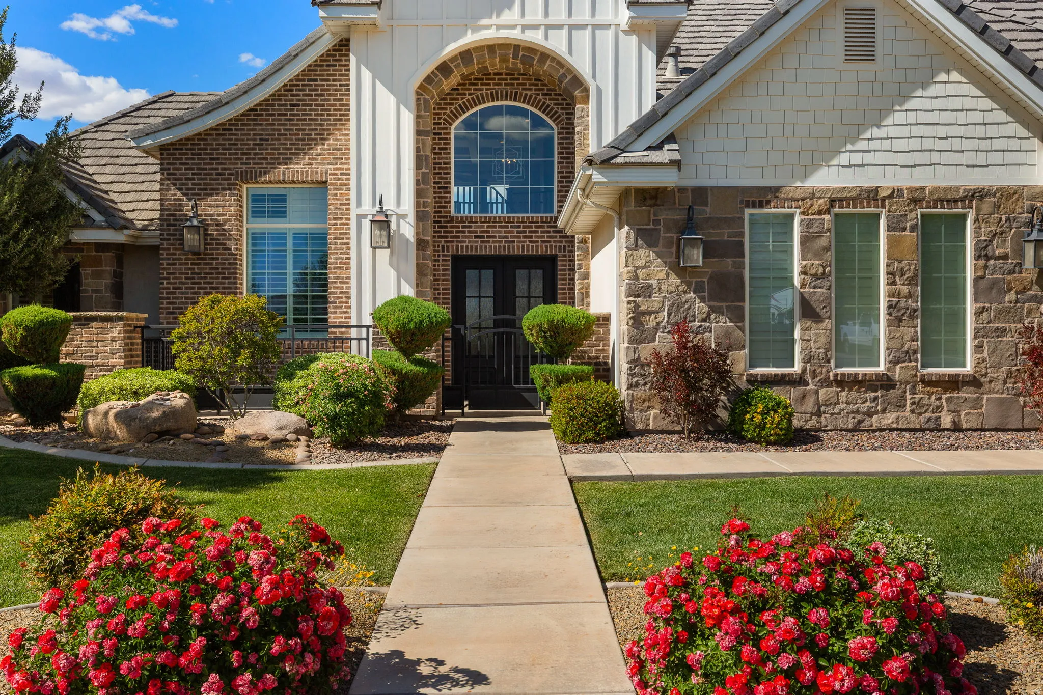 Brick and stone facade featuring a prominent arched entry with double doors
