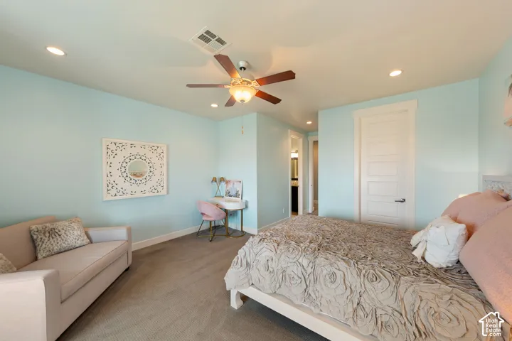 Carpeted bedroom with a ceiling fan, recessed lighting, and a five-panel interior door