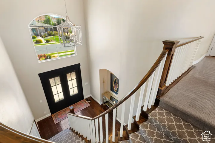 Two-story entryway featuring a dark wood-finish double entry door with frosted glass panes