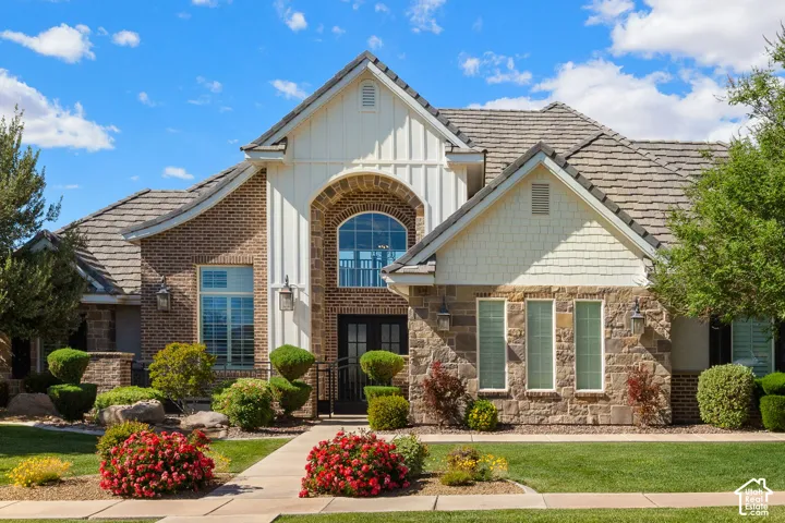 Stately brick and stone facade featuring a prominent arched entry with transom window