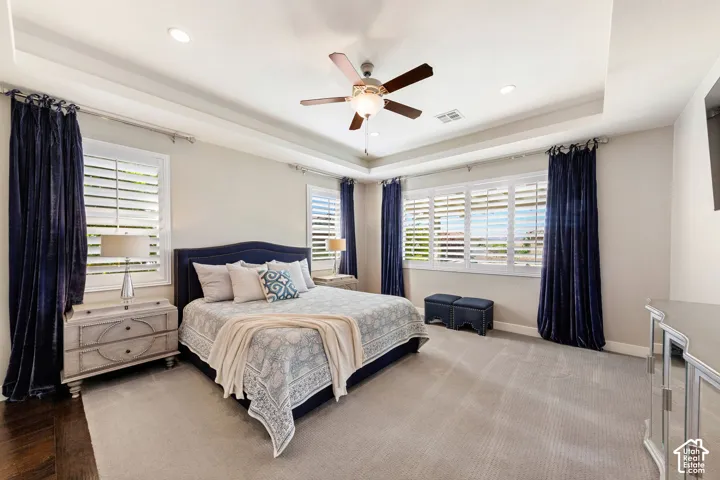 Carpeted room with a tray ceiling and recessed lighting