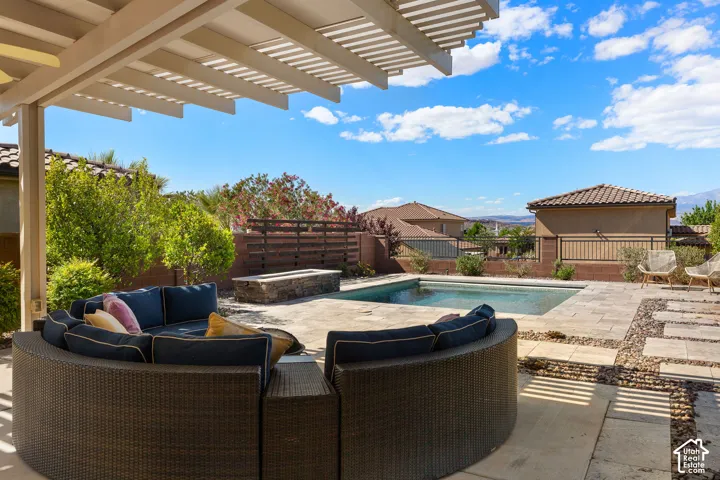 Expansive backyard featuring a pergola, swimming pool, stone fire pit, and paver patio