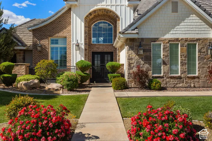 Brick and stone facade featuring a prominent arched entry with double doors