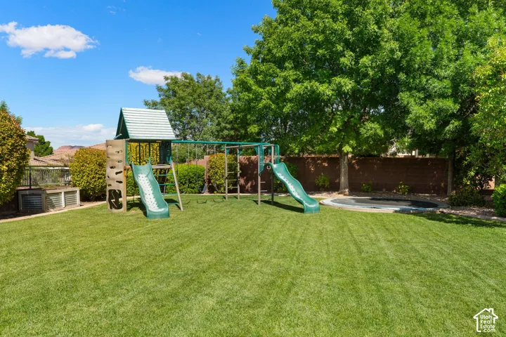 Expansive backyard featuring a lush green lawn, mature trees, and a privacy fence