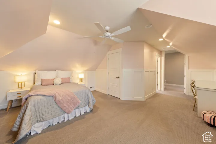 Room featuring sloped ceilings, recessed lighting, a ceiling fan, wainscoting, and carpet flooring