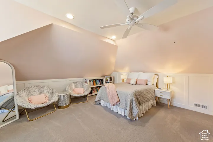 Carpeted room featuring a sloped ceiling, recessed lighting, and a ceiling fan