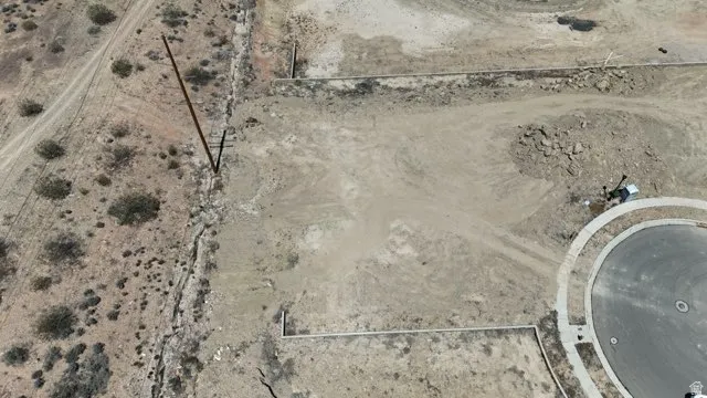 Expansive undeveloped parcel featuring a cul-de-sac with paved street and concrete curbing