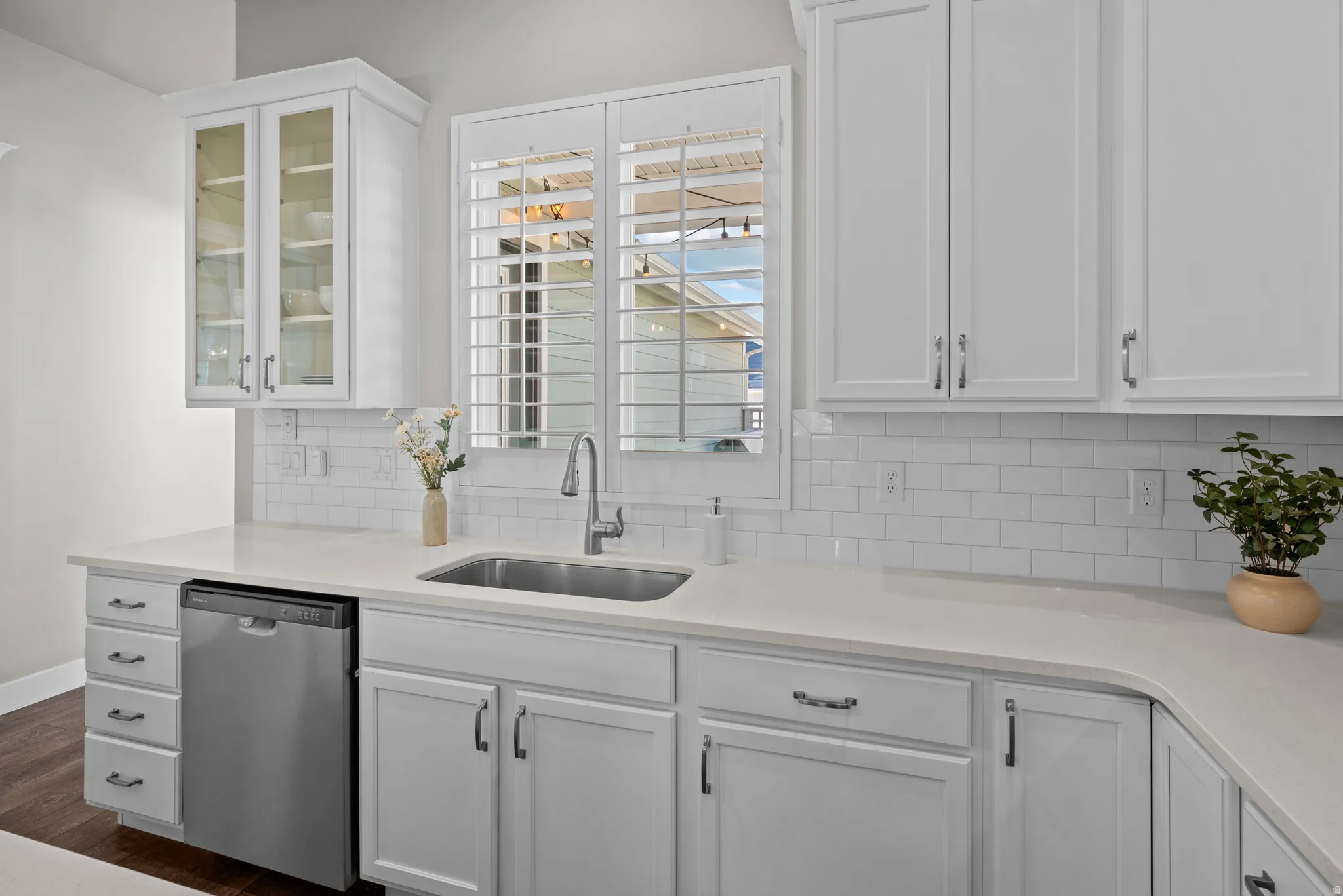 Kitchen with white shaker cabinetry, light countertops, and a subway tile backsplash