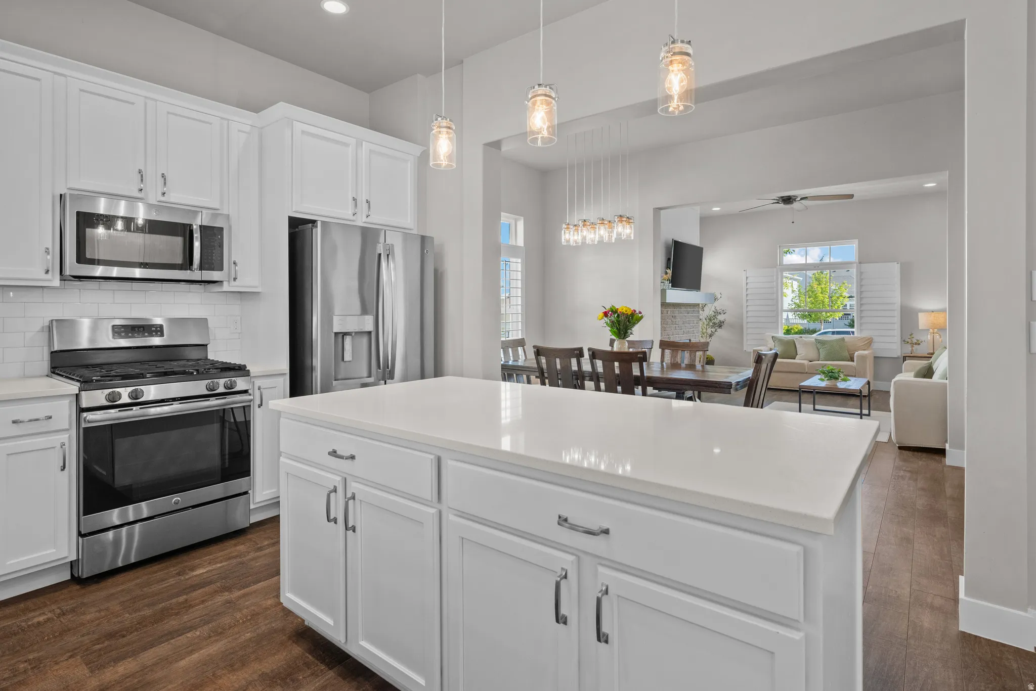 Kitchen featuring white cabinetry, stainless steel appliances, white subway tile backsplash, and wood-finish flooring