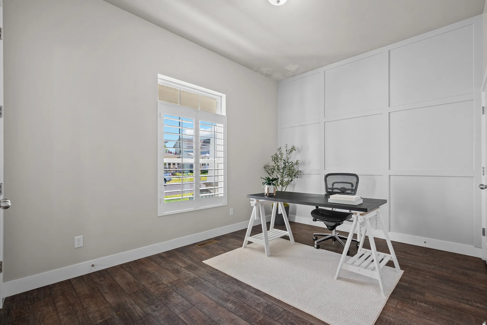 Interior space featuring dark wood-finish flooring, white baseboards, and light-toned walls