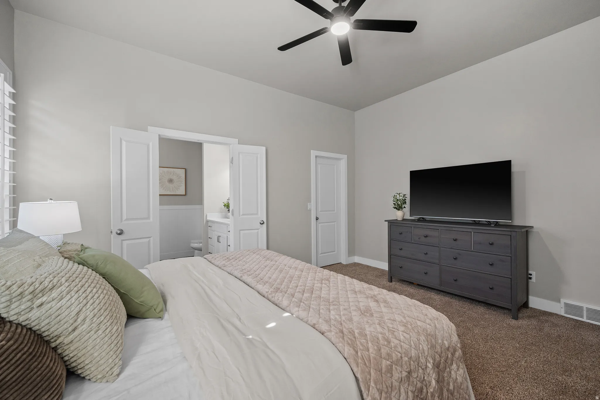 Spacious room featuring vaulted ceilings, neutral wall tones, and plush carpeting