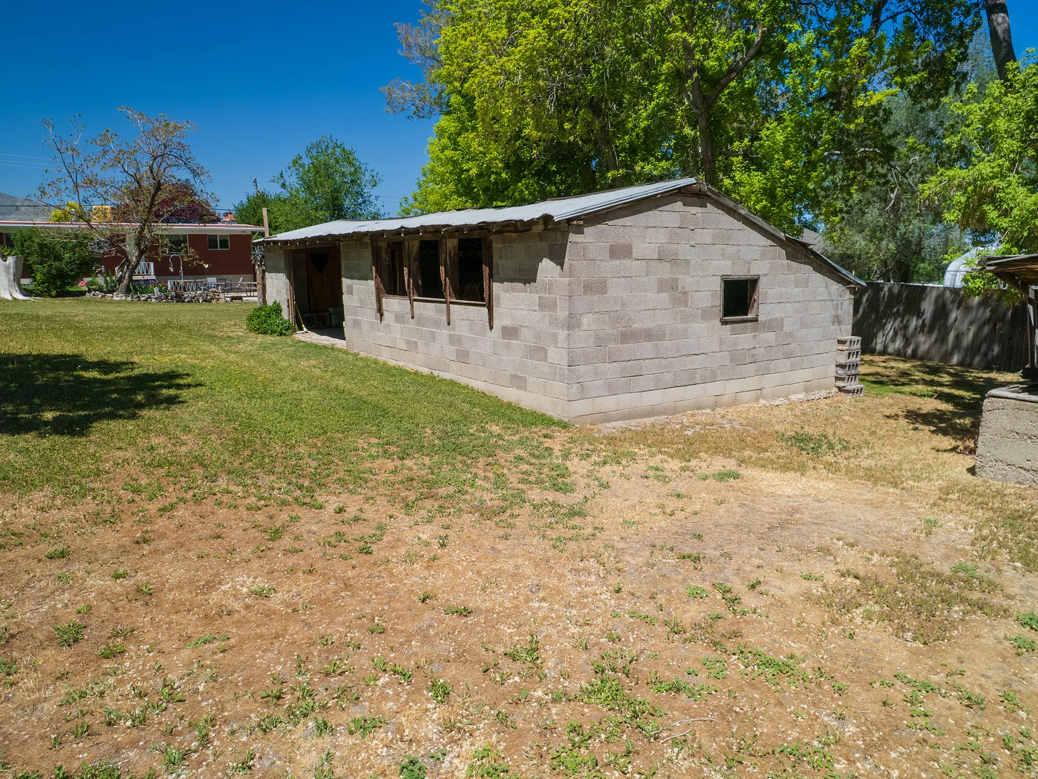 Detached structure featuring concrete block construction and a metal roof