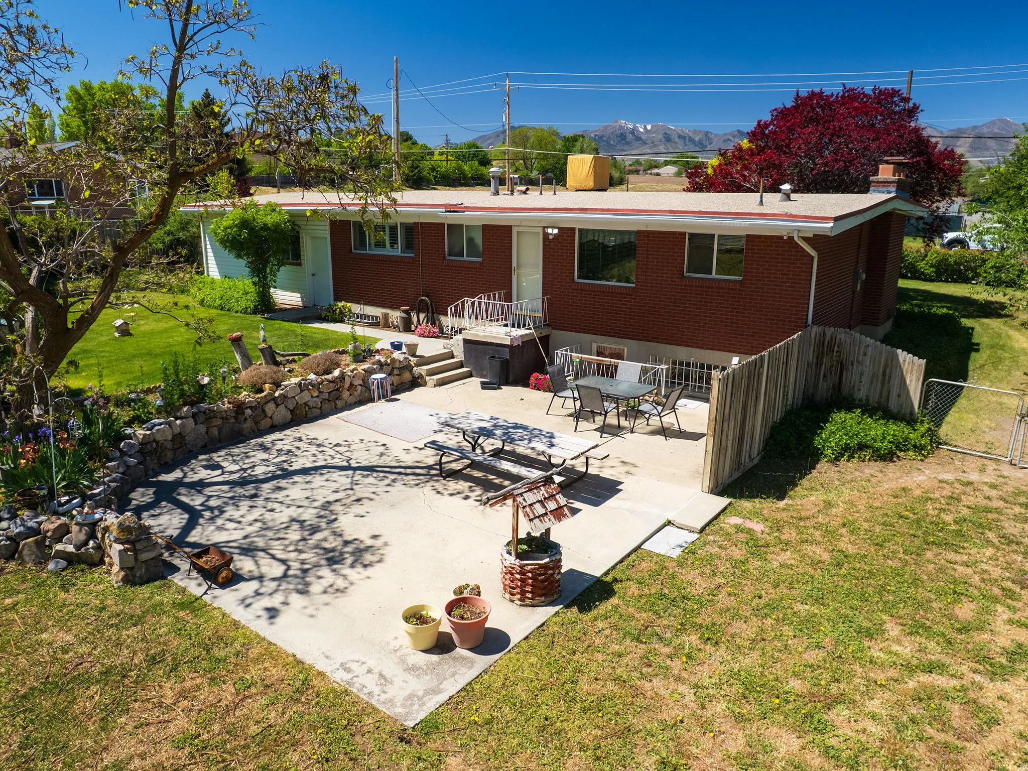 Rear exterior featuring a brick facade, white trim, and a concrete patio