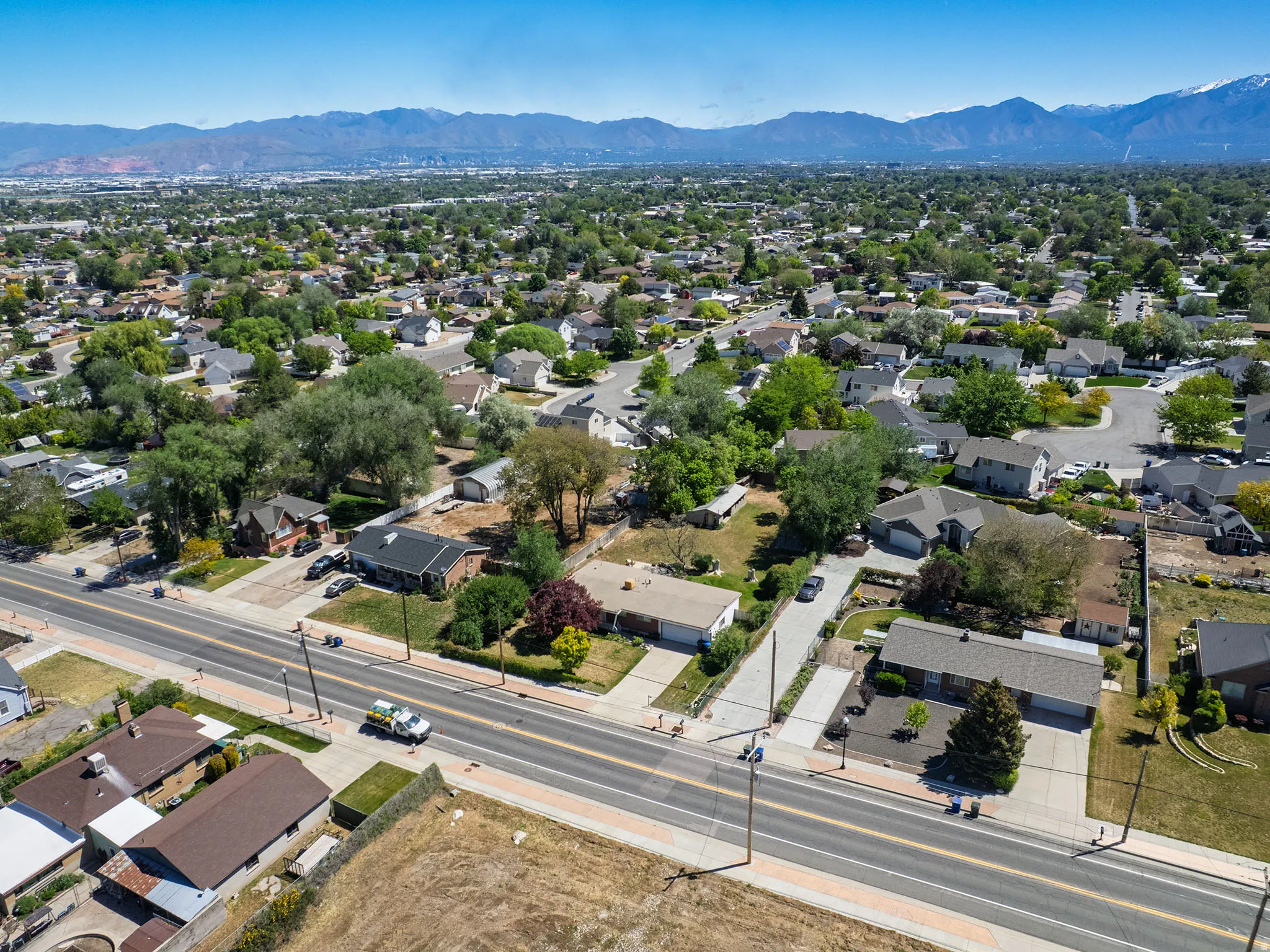 Expansive residential area featuring numerous mature trees and a distant mountain range