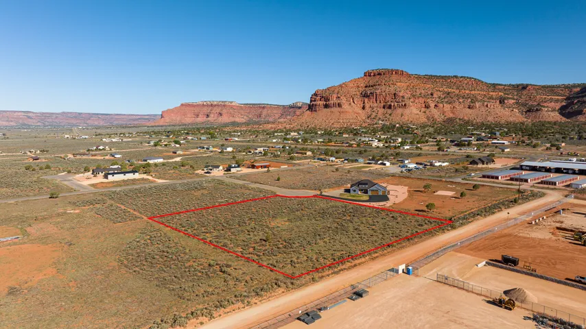 Expansive undeveloped land parcel with desert foliage and red rock mountain backdrop