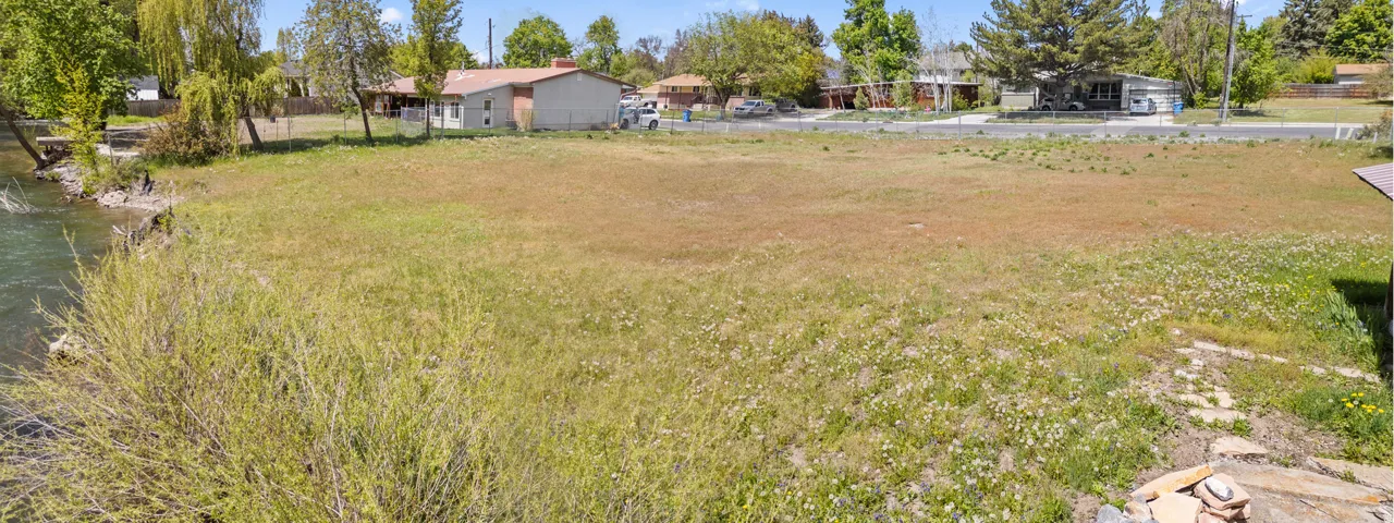 Expansive grassy lot bordering a tranquil waterway