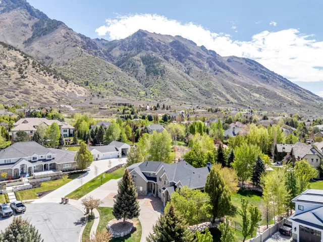 Expansive property featuring a stone and siding exterior, a circular driveway, and a multi-car garage