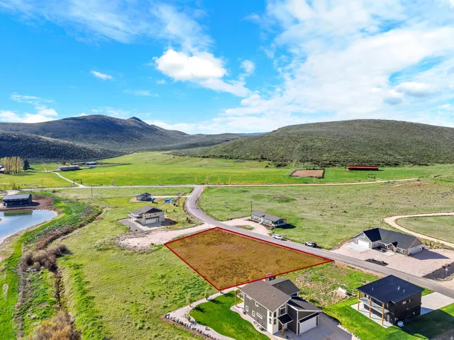 Expansive lot featuring a defined perimeter, surrounded by green landscape and distant hills