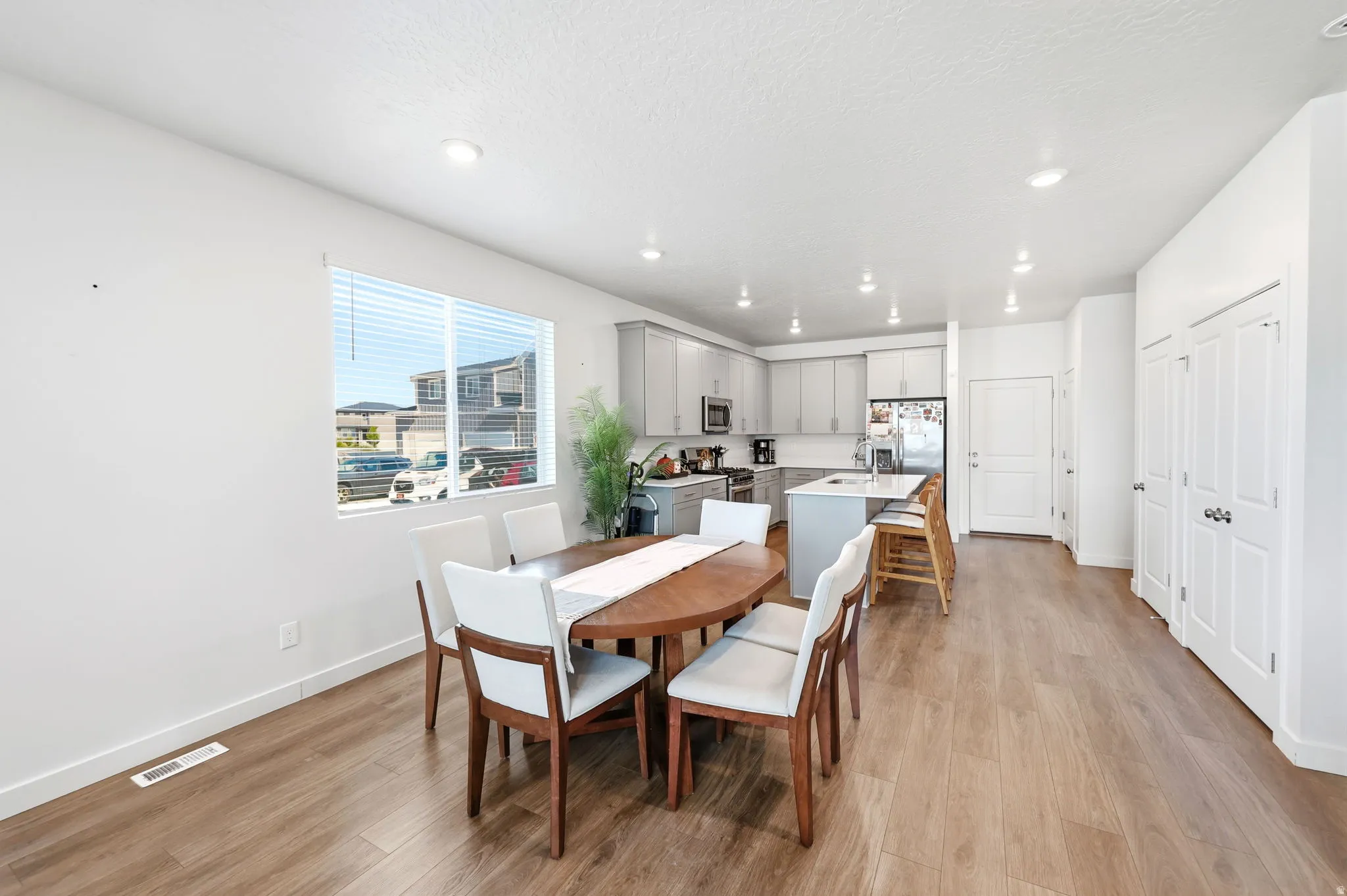 Open-concept dining area featuring wood-finish flooring and recessed lighting
