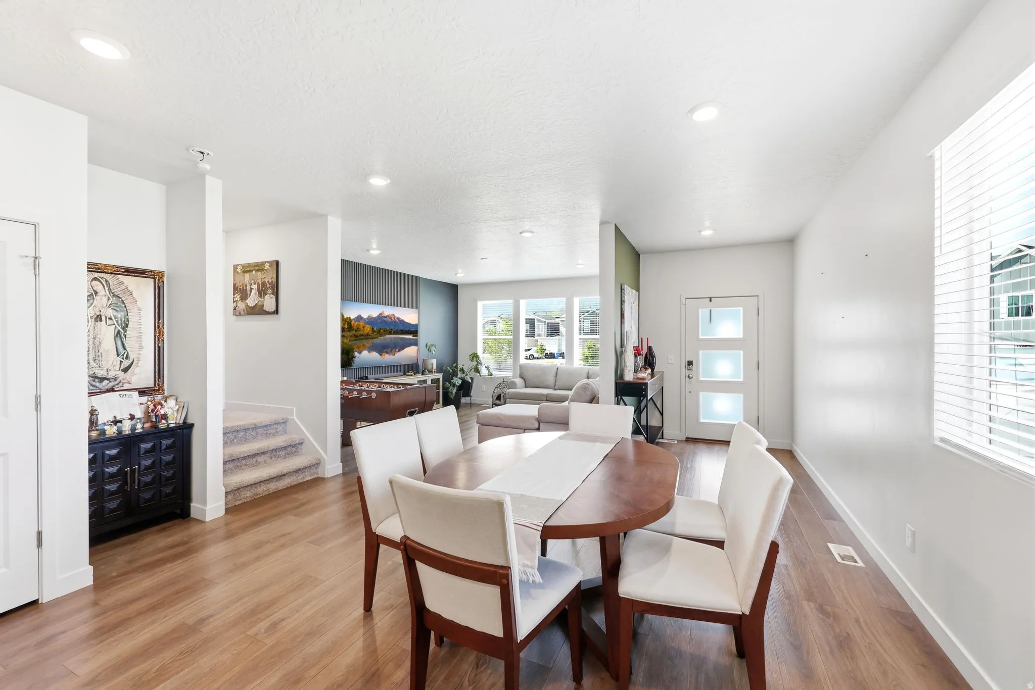 Open-concept living space featuring wood-finish flooring, recessed lighting, and a white interior door