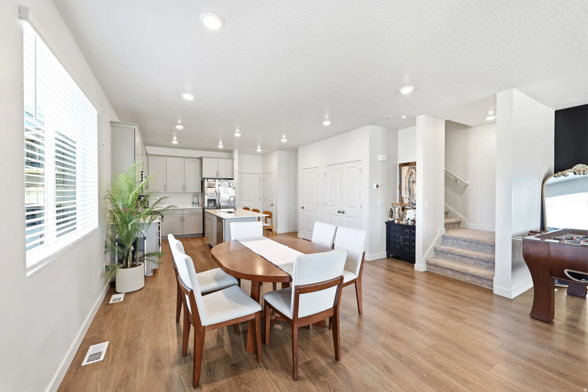 Open-concept living area featuring wood-finish flooring, recessed lighting, and a neutral color palette